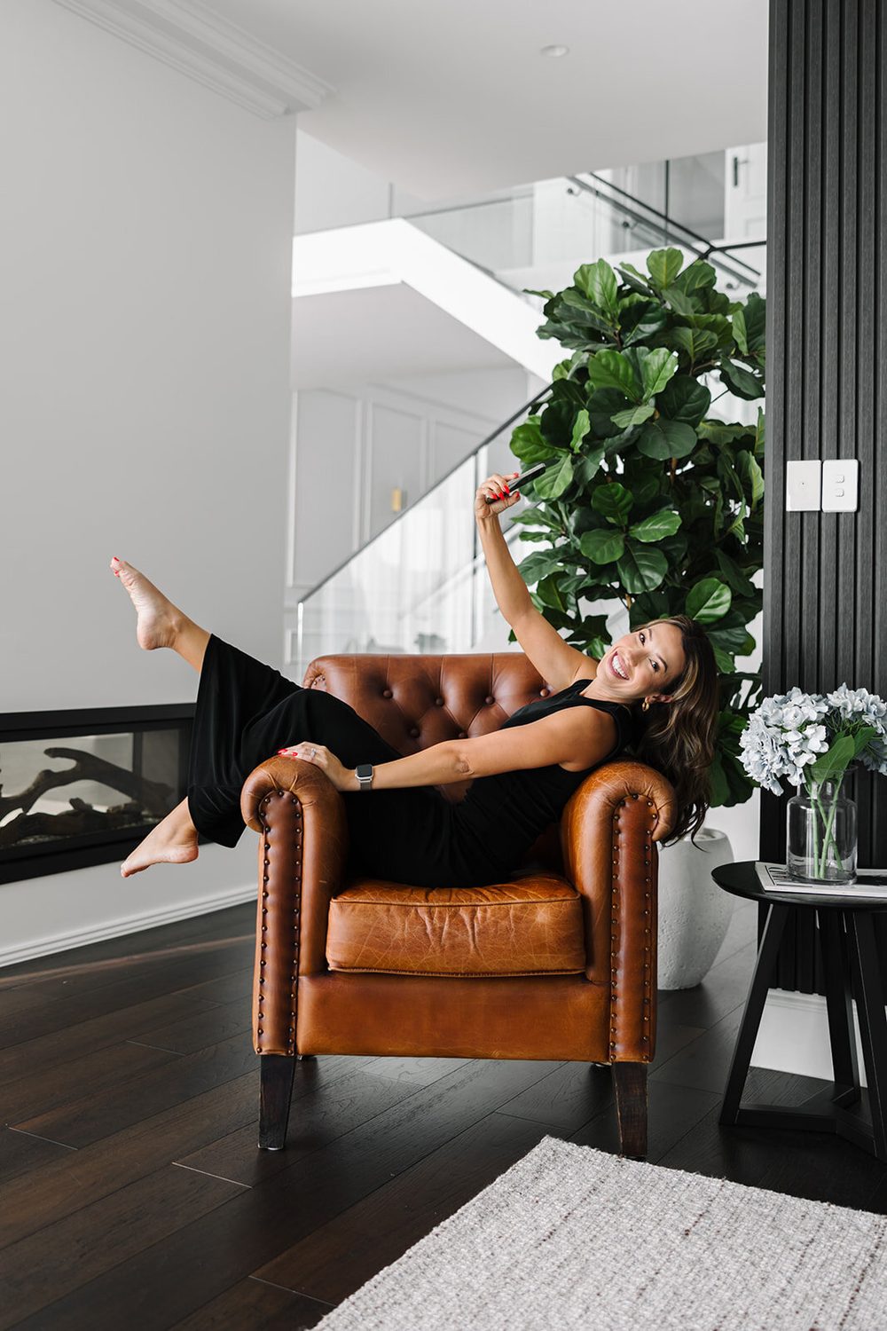 Tracy Harris at home, feet up on the arm of a leather chair