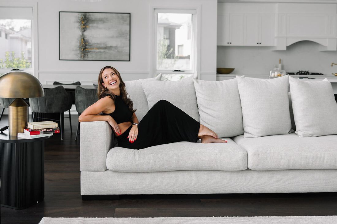 Tracy sitting back on a couch, laughing